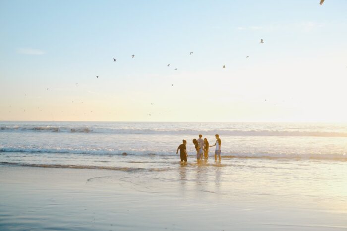 Groupe profitant de ses vacances tout en parlant les pieds dans l'eau