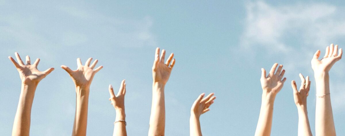 Photo d'un groupe qui lève les bras, illustrant le séminaire d'entreprise