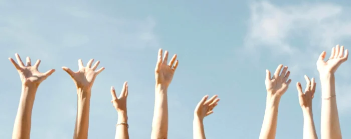 Photo d'un groupe qui lève les bras, illustrant le séminaire d'entreprise