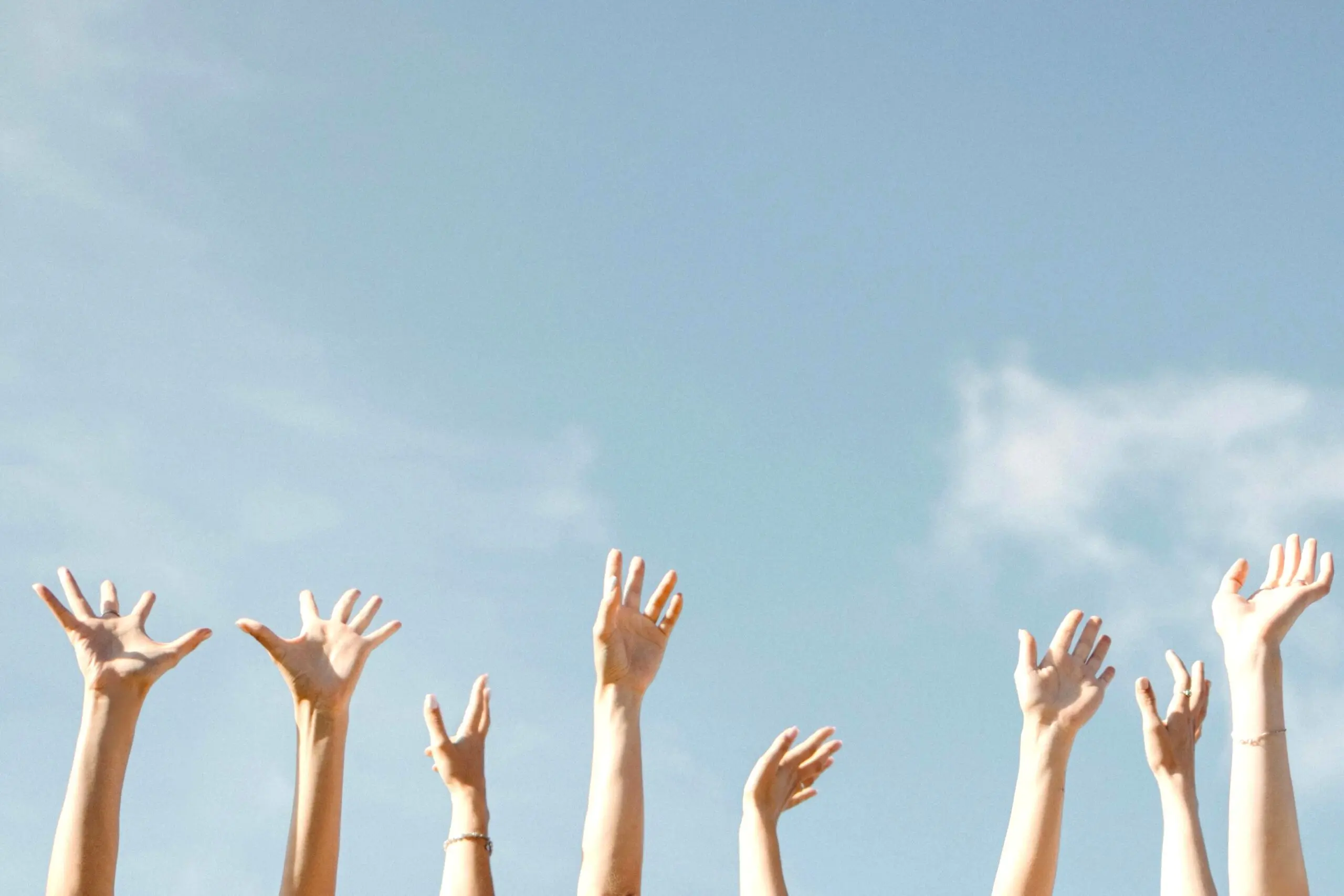 Photo d'un groupe qui lève les bras, illustrant le séminaire d'entreprise
